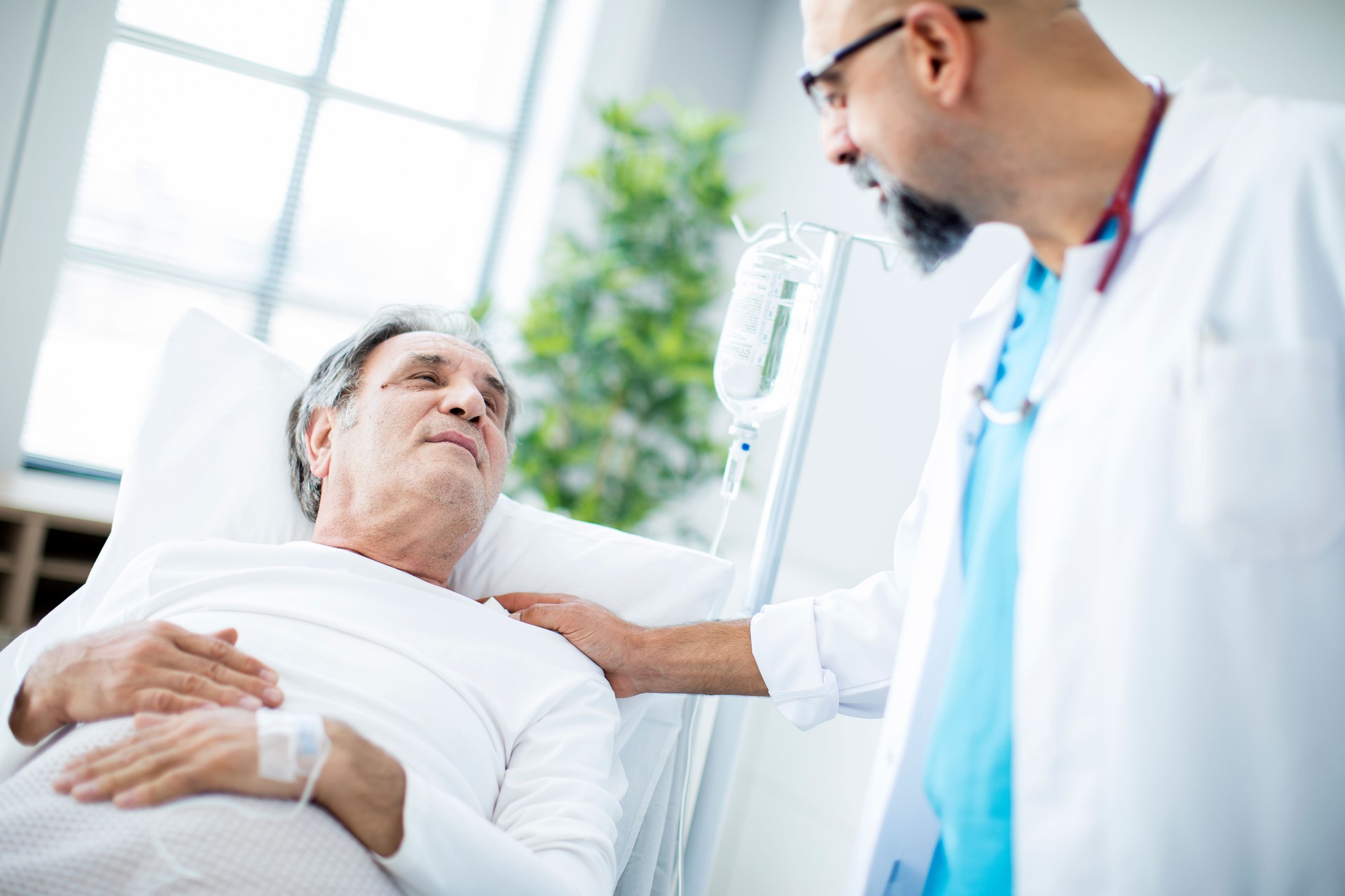 Doctor talking to patient in hospital bed