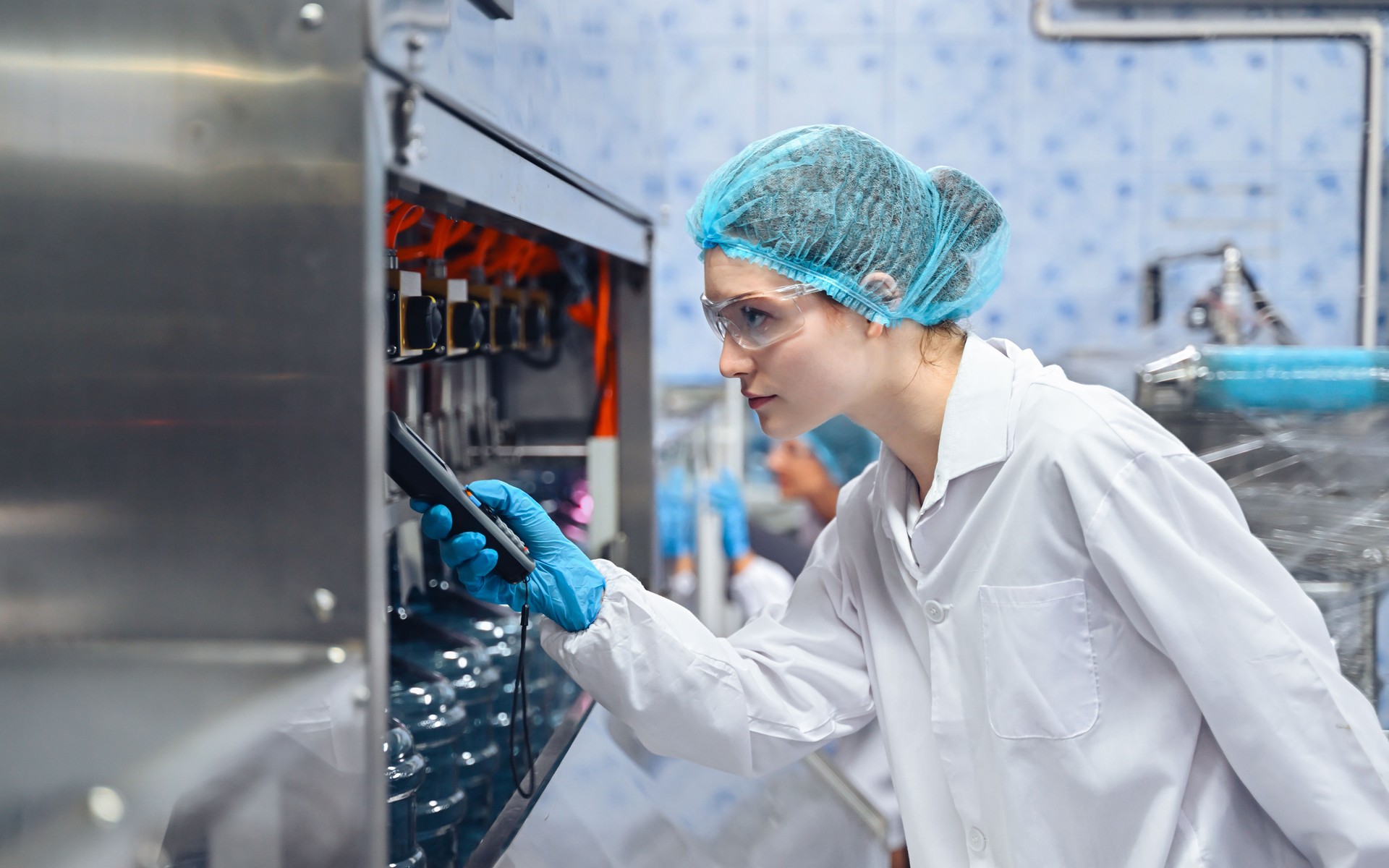 Bottling factory worker inspecting quality of water bottles before shipment. Reverse osmosis system used in plant. water purity and maintaining quality control in bottling process. High quality photo